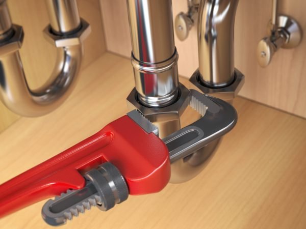 Pllumber using an ajustable wrench to repair a water pipe under the sink. 3d illustration